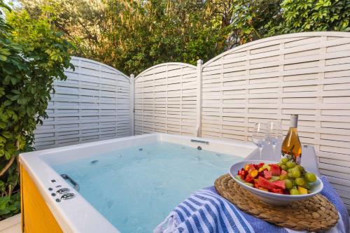 a bowl of fruit and a bottle of wine in a tub at Skiathos Avaton Garden, Philian Hotels and Resorts in Skiathos