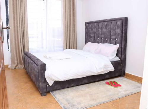 a bed with a black leather headboard in a bedroom at Lulu Stays 2 Bedroom in Nyahururu