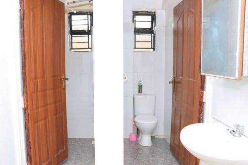 Duas fotografias de uma casa de banho com WC e lavatório. em Lulu Stays 2 Bedroom em Nyahururu