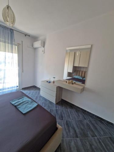 una camera da letto con un letto e un mobiletto con specchio di CasaNova a Vlorë