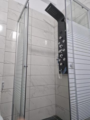 un bagno con doccia con porta in vetro di CasaNova a Vlorë