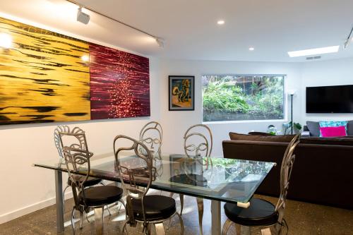 a dining room with a glass table and chairs at Kate Owen Art House in Hobart
