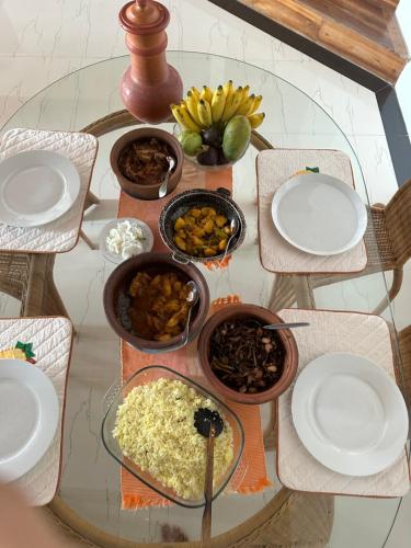 a table with bowls of food on a glass table at Kande Home in Kandy