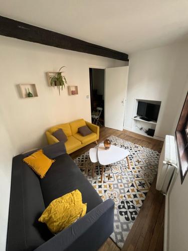 uma sala de estar com um sofá e uma mesa em Maison atypique à colombage Poitiers Centre em Poitiers