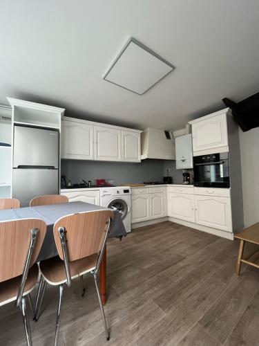 uma cozinha com armários brancos e uma mesa e cadeiras em Maison atypique à colombage Poitiers Centre em Poitiers