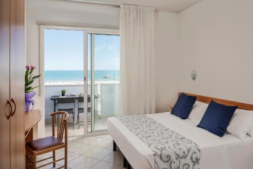 a bedroom with a bed and a balcony with the ocean at Residence Hotel Piccadilly in Rimini