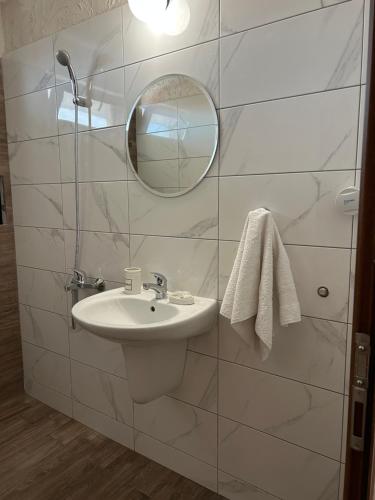 a white bathroom with a sink and a mirror at Stoyko's Guest House in Pomorie