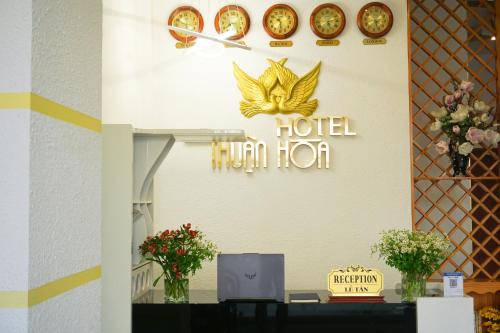 een hotel menselijke horizons teken op een muur met bloemen bij Thuận Hòa Hotel in Xuan An