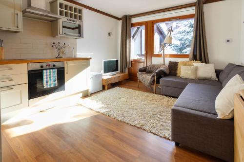 un salon avec un canapé et une table dans l'établissement Les Grand Balcon - 2ch - 2 balcons - Randonnée - Escalade - Lac des Chavants, aux Houches