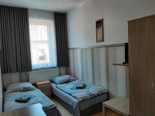 a hotel room with two beds and a window at Noclegi Viktor in Kalwaria Zebrzydowska
