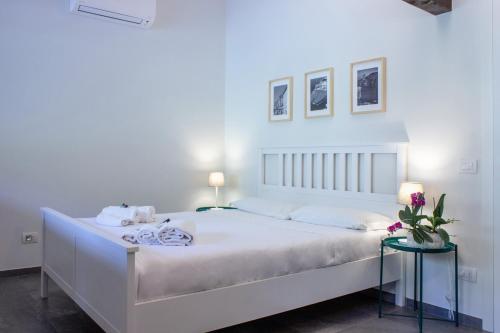 een slaapkamer met een groot wit bed en 2 tafels bij Villa Onedo in Abbadia Lariana
