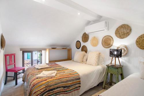a white bedroom with a bed and a chair at Casa River Sun in Valada
