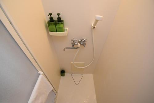 łazienka z toaletą i 2 butelkami na ścianie w obiekcie Yadomachi sakura - Vacation STAY 54783v w mieście Hakodate