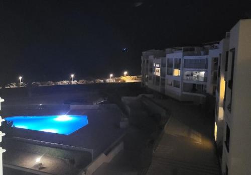 - une piscine la nuit à côté d'un bâtiment dans l'établissement Le refuge côté mer, au Cap d'Agde