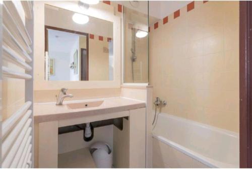 une salle de bain avec un lavabo, un miroir et une baignoire dans l'établissement Le refuge côté mer, au Cap d'Agde