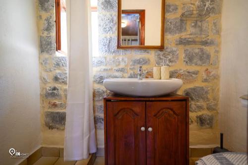 a bathroom with a sink and a mirror at Faskomilo Stone House On The Beach in Khalíkia