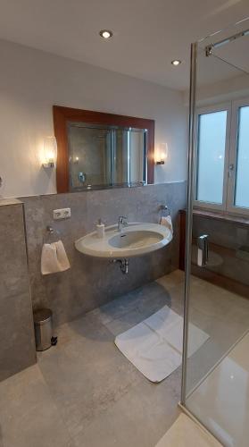 a bathroom with a sink and a shower at Pension Langerspacher in Grabenstätt