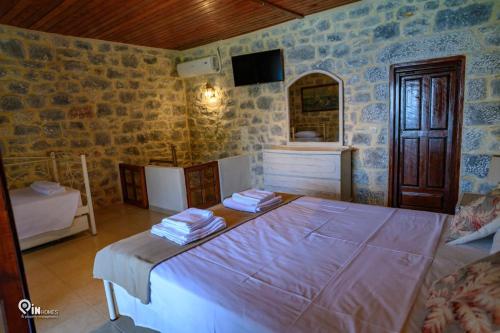 a bedroom with a large bed and a mirror at Faskomilo Stone House On The Beach in Khalíkia