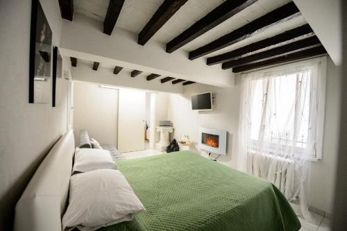 um quarto com uma cama verde e uma lareira em TIFFANY TORTELLINOSUITE Modena em Módena