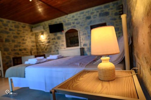 a lamp sitting on a table next to a bed at Faskomilo Stone House On The Beach in Khalíkia