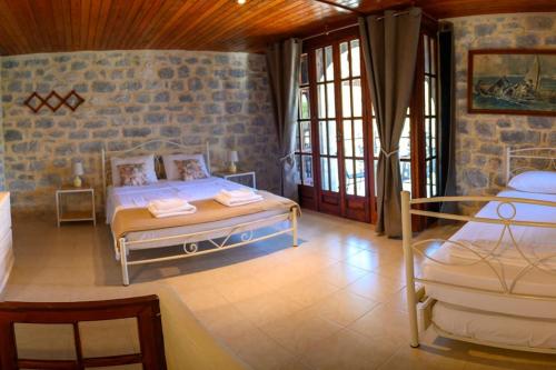 a bedroom with two beds and a brick wall at Faskomilo Stone House On The Beach in Khalíkia