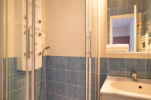 a bathroom with a shower and a sink at The Originals City, Clos de l'Orgerie ,Château Gonthier in Château-Gontier