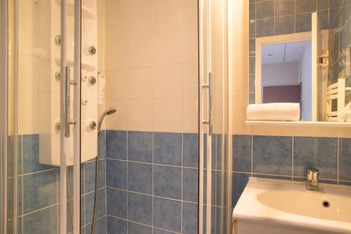 a bathroom with a shower and a sink at The Originals City, Le Clos de l'Orgerie, Laval Sud (Inter-Hotel) in Château-Gontier