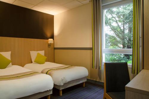 pokój hotelowy z 2 łóżkami i oknem w obiekcie The Originals City, Le Clos de l'Orgerie, Laval Sud (Inter-Hotel) w mieście Château-Gontier