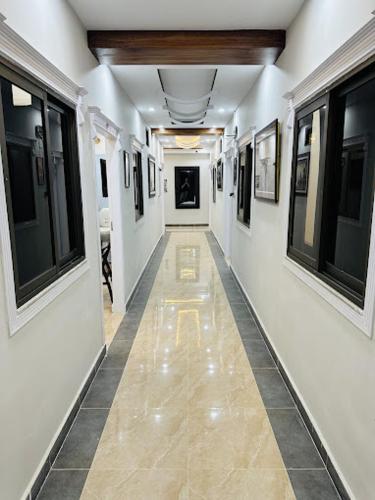 a hallway with white walls and a long hallway with windows at Moven Inn Hotel Islamabad in Islamabad