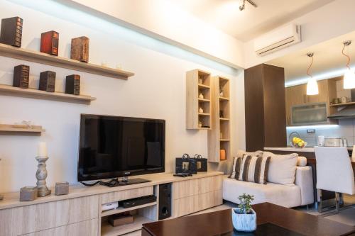 a living room with a flat screen tv and a couch at Filia Home in Agios Nikolaos