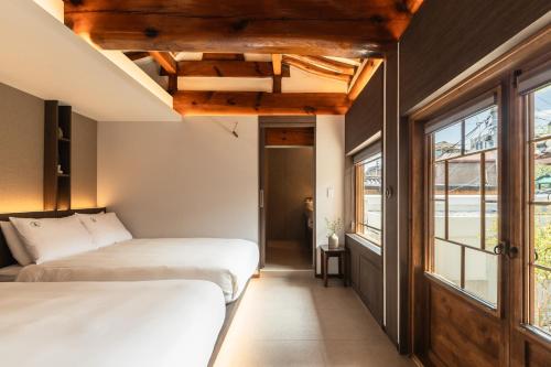 a bedroom with two beds and a window at Luxury hanok with private bathtub - SW13 in Seoul