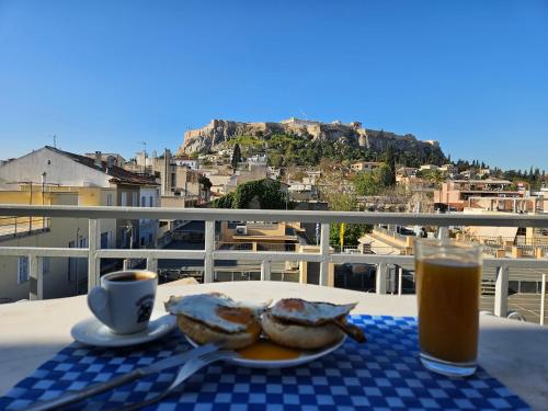 a table with a plate of food and a cup of coffee at Luxurious Top Floor Acropolis View Loft in Plaka - Newly Refurbished in Athens