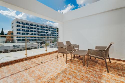 a balcony with chairs and a view of a building at Seafront Protaras Apartments in Protaras