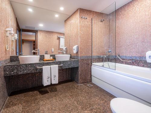 a bathroom with two sinks and a tub and a toilet at Asteria Family Resort Belek in Belek