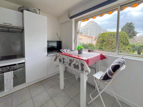une petite cuisine avec une table et une fenêtre dans l'établissement La Studette Marina 06, à Villeneuve-Loubet