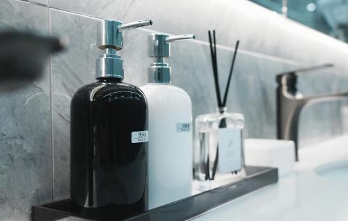 dwie butelki mydła siedzące na ladzie w łazience w obiekcie Lemon Hotel- Hangzhou West Lake w mieście Hangzhou