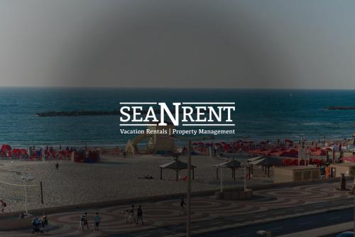 a large sign on a beach with the ocean at Sea Breeze Netanya Retreat by Sea N' Rent in Netanya