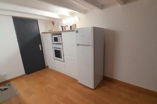 une cuisine avec un réfrigérateur blanc dans une pièce dans l'établissement Jolie Duplex Quai de la Joliette, à Marseille