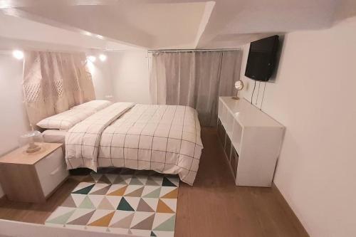 une petite chambre avec un lit et une télévision dans l'établissement Jolie Duplex Quai de la Joliette, à Marseille