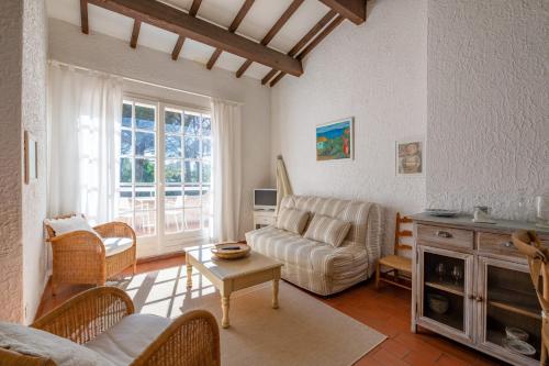 un salon avec un canapé et une table dans l'établissement Le Mas des Oliviers - Welkeys, à La Croix-Valmer