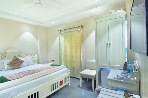 a bedroom with a bed and a cabinet and a chair at The Pinky Villa - Heritage Boutique Suites- New Delhi in New Delhi