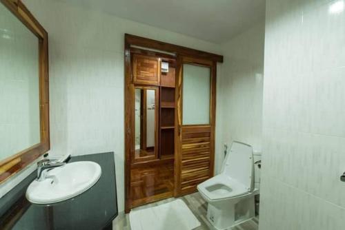 a bathroom with a sink and a toilet and a mirror at Sky View Hotel Buriram in Buriram