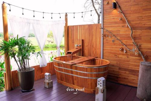 a wooden bath tub sitting on top of a deck at Ayla Chalet in Phrae