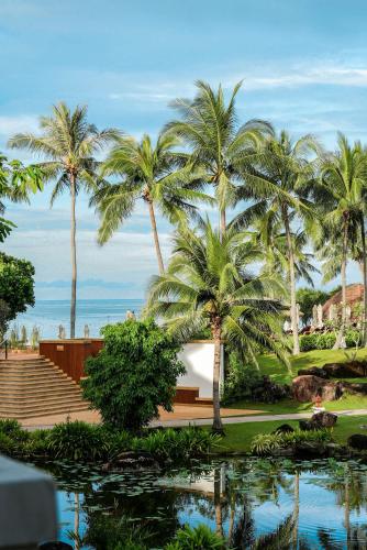 a view of a resort with palm trees and a pond at Rawi Warin Resort And Spa - SHA Extra Plus in Ko Lanta