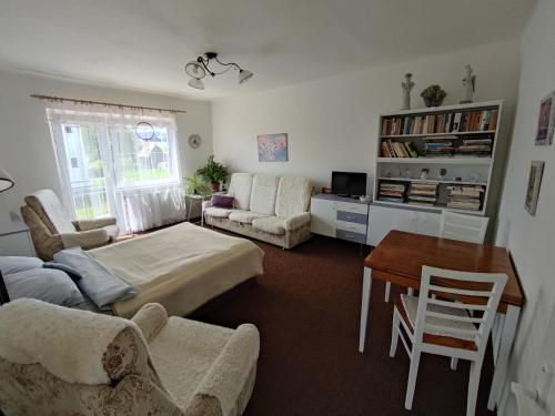 uma sala de estar com uma cama, uma mesa e cadeiras em Apartmán Donská em Liberec