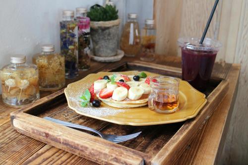 a plate of pancakes with fruit on a wooden table at GMI Hotel and Benquet Jaipur in Jaipur