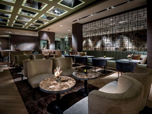 a restaurant with couches and tables and chairs at Van der Valk Hotel Dordrecht in Dordrecht