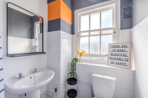 een badkamer met een wastafel, een toilet en een raam bij Sea View I Central Brighton Location I Sleep 3 I Next to Brighton Beach in Brighton & Hove