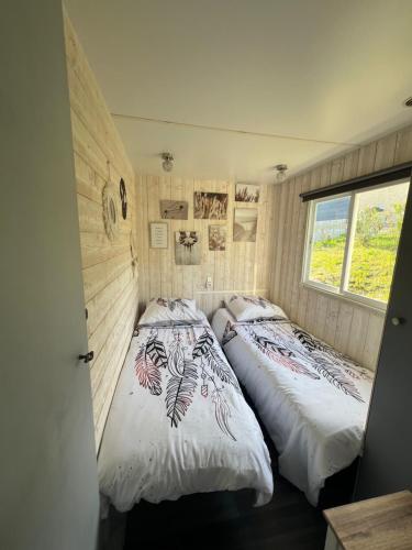 2 camas en un dormitorio pequeño con ventana en Chalet de Bonnat, en Salignac Eyvigues