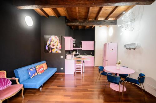 a living room with a blue couch and a table at PINK HOUSE TORTELLINOSUITE Modena in Modena